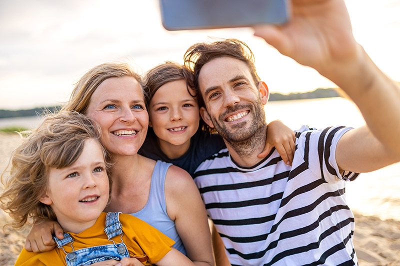 Family taking self portrait on beach stock photo
